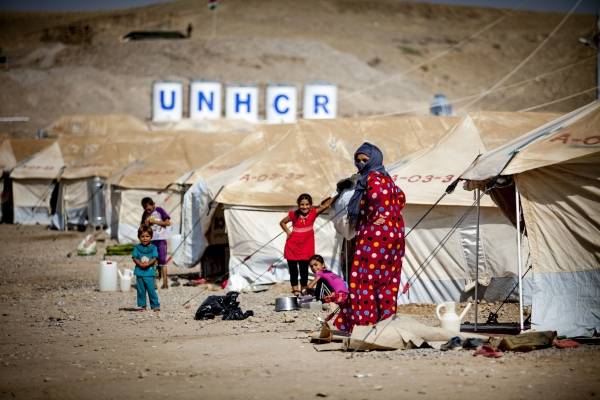 Flygtninge i Irak står foran en provisorisk teltlejr. Shutterbox Editorial/Flo Smith